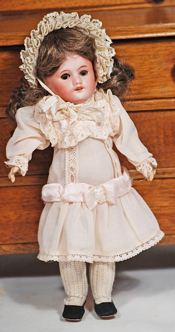 TINY FRENCH BISQUE DOLL BY S.F.B.J..: 93. TINY FRENCH BISQUE DOLL BY S.F.B.J. 8 ½”. Marks: France SFBJ 60. Bisque socket head, brown sleep eyes, tapered brows, open mouth, upper teeth, brown synthetic wig, French composition