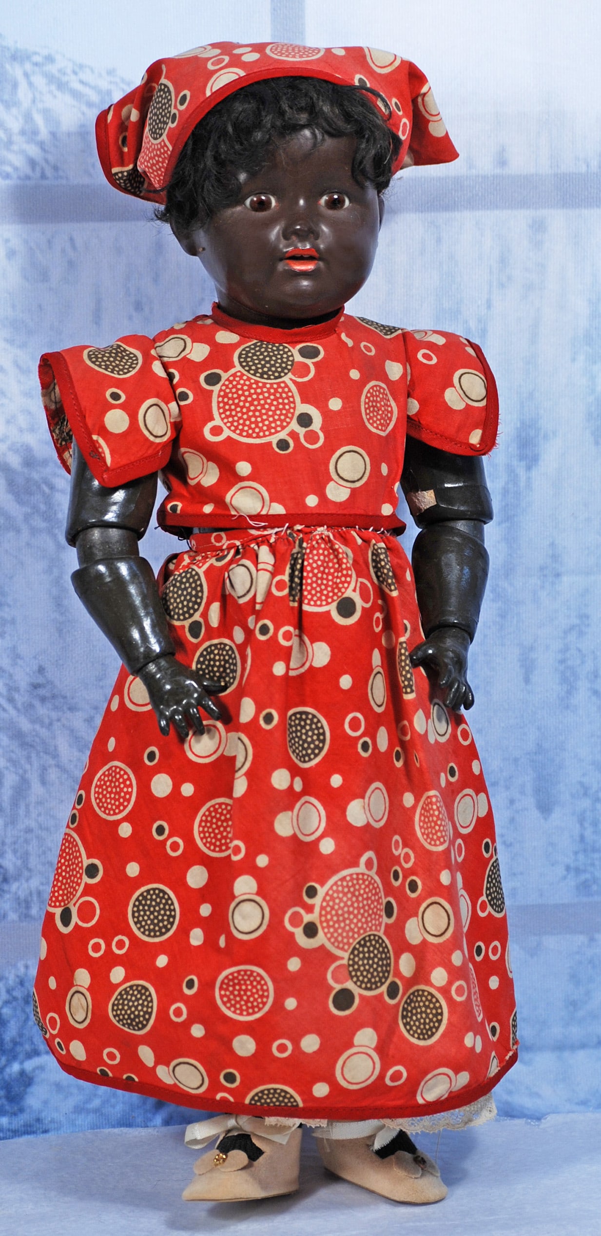 GERMAN BROWN BISQUE CHILD BY MARSEILLE 16”: 16” Dark brown bisque socket head, stationary brown glass eyes, painted lashes, open mouth, upper teeth, original black mohair wig, brown composition and wooden ball-jointed body, red cotton pri