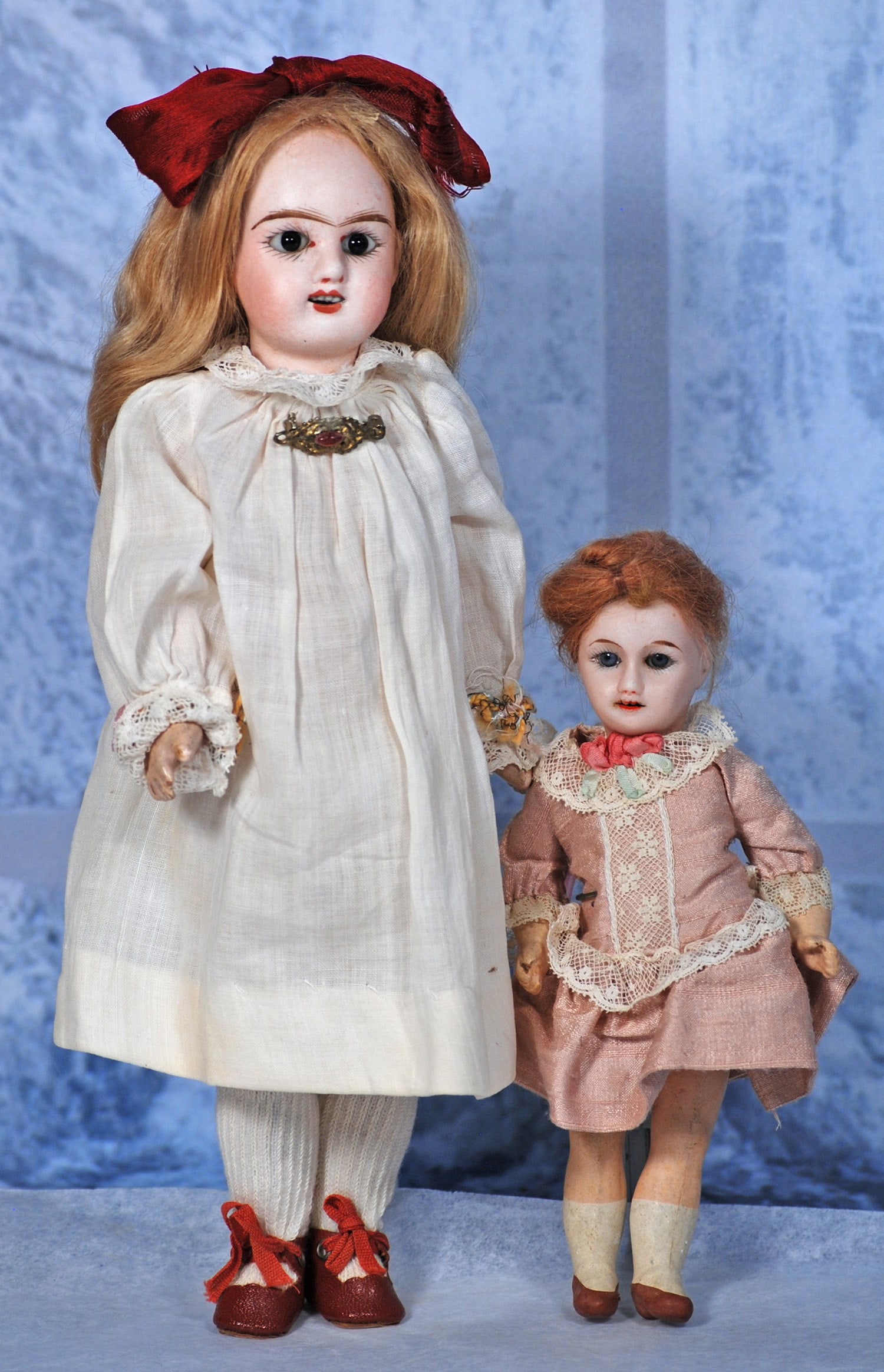 TWO FRENCH BISQUE DOLLS: (1) 6” doll marked Unis France, bisque socket head, stationary blue glass eyes, open mouth, upper teeth, mohair wig, five-piece jointed composition body, painted shoes and socks, rose silk dress