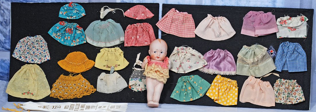 ALL-BISQUE DOLL WITH WARDROBE: 5 ½” all-bisque doll with painted hair and features, jointed at shoulders, silk and lace costume plus additional hand-made wardrobe as illustrated Commentary