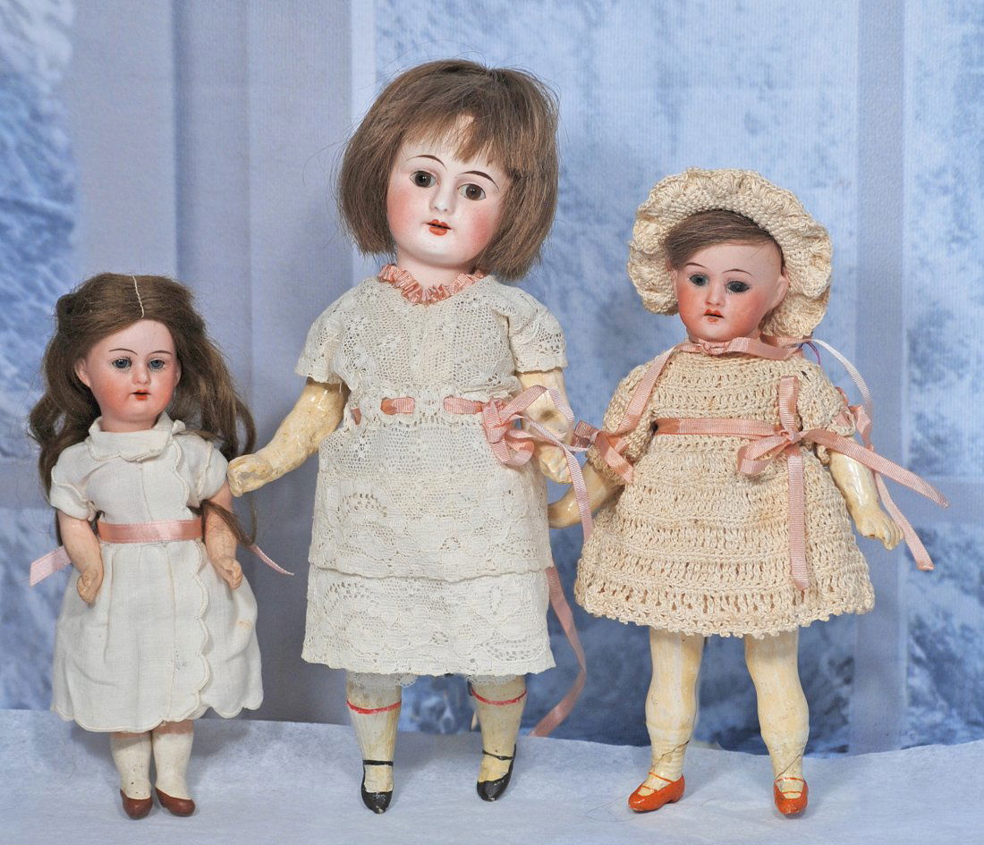 THREE SMALL GERMAN BISQUE DOLLS: THREE SMALL GERMAN BISQUE DOLLS. Each has bisque socket head, glass eyes, open mouth, upper teeth, human hair wig, five-piece composition jointed body, painted shoes and socks. 8” A.M. 390; 7&rd