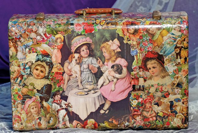 DECOUPAGED LUGGAGE CASE: DECOUPAGED LUGGAGE CASE. 21” W. x 14” H. Molded case is covered all over in colored decoupaged Victorian scenes, linen-lined interior with leather straps, metal closure, leather handle. Commentary