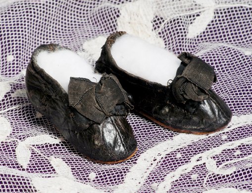 PAIR OF BLACK FRENCH SHOES FOR POUPEE: PAIR OF BLACK FRENCH SHOES FOR POUPEE. 2 ¼”. Soft black leather shoes have tiny wooden heels, silk-bound edges and large silk bows, leather soles. Commentary: Antique shoes of fine quality, very go