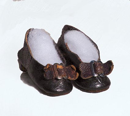 FRENCH LEATHER DOLL SHOES: FRENCH LEATHER DOLL SHOES. Marks: C.M. 2” L. Dark leather slippers with tapered wooden heels, leather bows and silver buckles. Commentary: Antique slippers in good original condition.