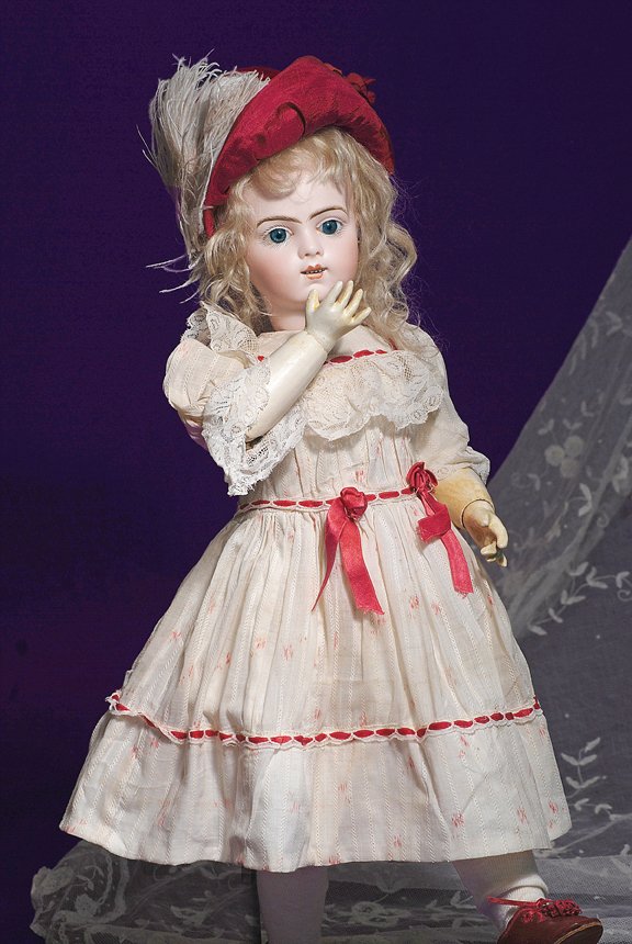 A VERY PRETTY “BRU BEBE MECANIQUE” KISS-THROWING B: A VERY PRETTY “BRU BEBE MECANIQUE” KISS-THROWING BEBE. Marks: Bru Jne R 9. 22”. Bisque socket head with slightly smiling expression and blue paperweight eyes, painted lashes, feathered and brush