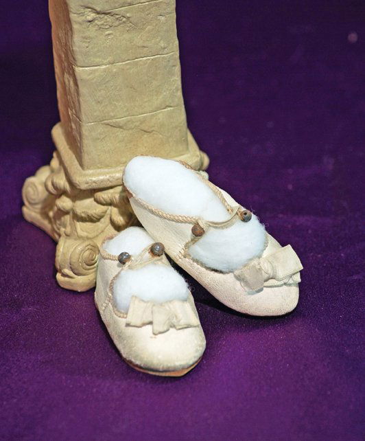 ANTIQUE FRENCH WHITE LEATHER DOLL SHOES: ANTIQUE FRENCH WHITE LEATHER DOLL SHOES. Marks: 6 depose and figure of doll. 3” L. White leather shoes with overcast edges, ankle button closing, ivory silk bows, leather soles. Commentary: Very goo