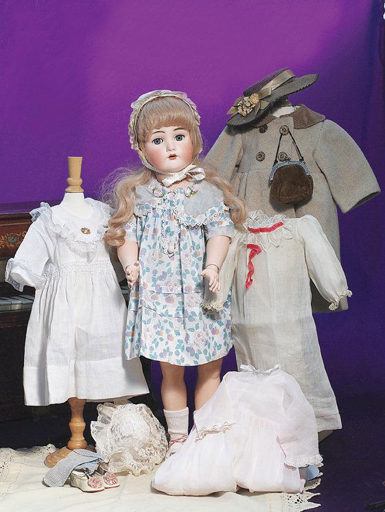 KAMMER & REINHARDT BISQUE DOLL IN FAO SWARZ TAGGED: KAMMER & REINHARDT BISQUE DOLL IN FAO SWARZ TAGGED DRESS PLUS WARDROBE. Marks: Simon & Halbig, K * R. 26”. Bisque socket head, blue sleep eyes, painted lashes and original applied upper lashes, feat