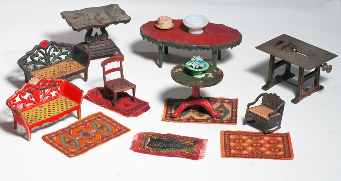 LARGE DOLLHOUSE FURNISHING GROUP: DOLLHOUSE FURNISHING GROUP. Includes: 4” H. steel table saw with Bing trademark sticker, two 4” L. fancy painted cast iron loveseats, 4” L., small cast iron chair, rocking chair, round pedestal 