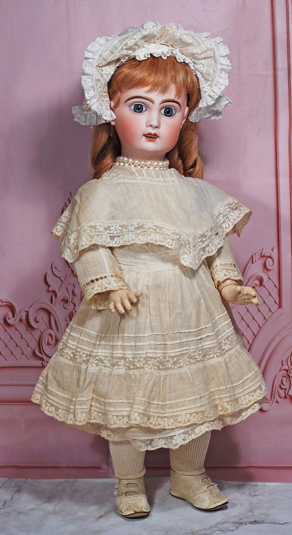 FRENCH BISQUE BEBE BY JUMEAU: 22” Marks: Depose Tete Jumeau Bte SGDG (red stamp) 10 Bisque socket head, blue paperweight eyes, painted lashes, eyeliner, feathered and brushstroked brows, pierced ears, open mouth, shaded and