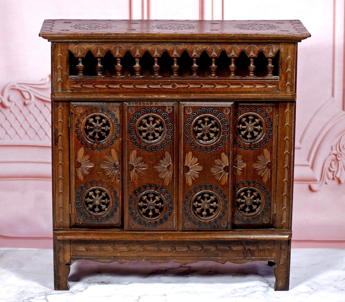 FRENCH WOODEN DOLL FURNITURE FROM BRITTANY: Four panel cupboard which is designed as a bed with sliding doors, has original dark finish and classic symbols of Brittany design including pinwheels, ball and stick, and incised florals Commentary: 