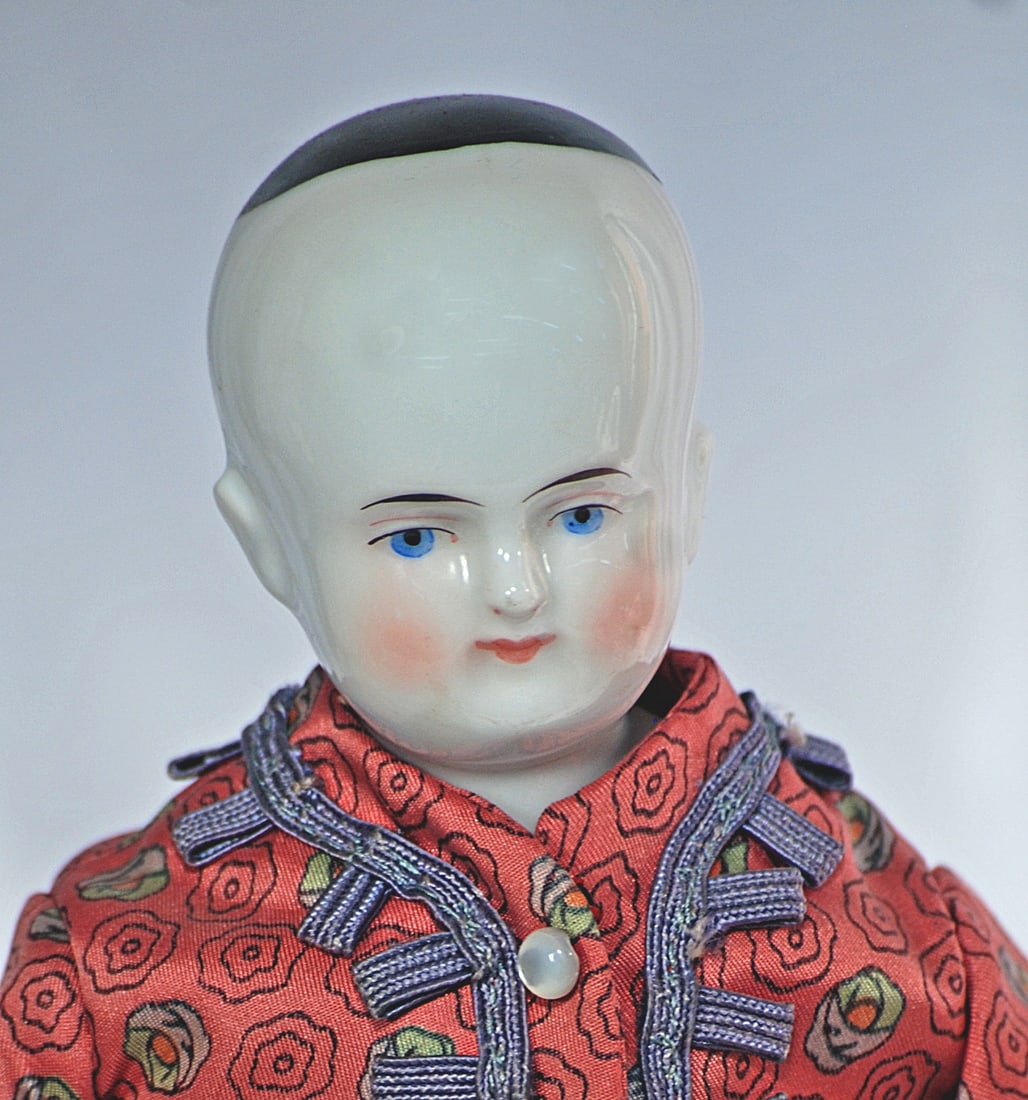 GERMAN PORCELAIN LADY KNOWN A BEIDERMEIER: 14 ½” Porcelain shoulderhead with painted black pate, painted features, blue eyes, red and black eyeliner, tapered brows, closed mouth, sculpted ears, cloth body with kid leather arms and sewn-on l