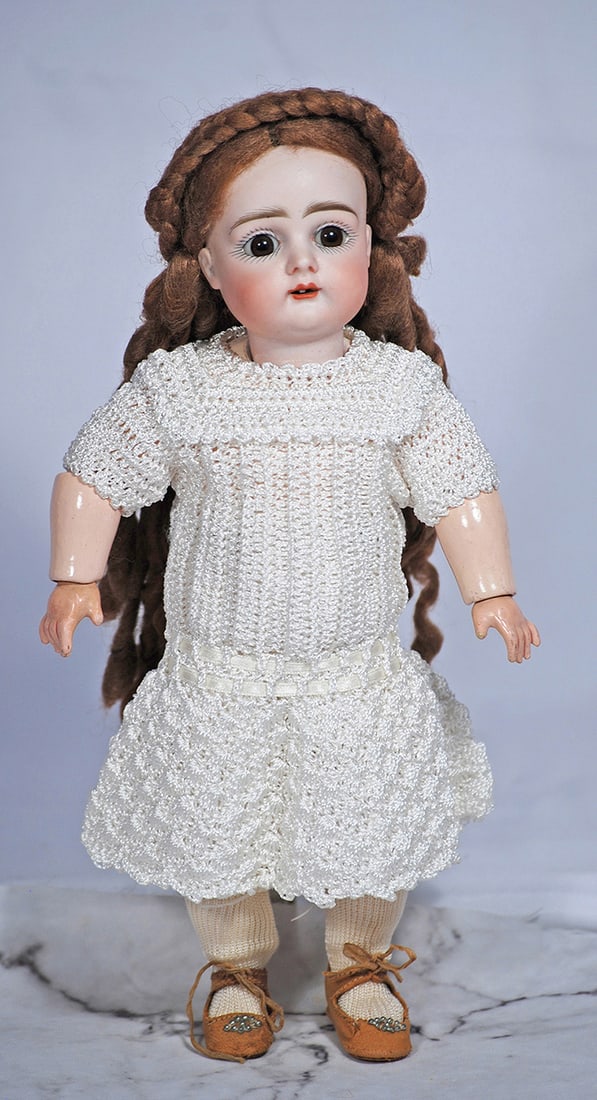 PETITE GERMAN BISQUE DOLL BY KESTNER, 10 ½”: Marks: 4 Bisque socket head, stationary brown glass eyes, painted lashes, feathered brows, open mouth, upper teeth, brown mohair wig, no pate, composition ball-jointed body, crocheted white dress, ant