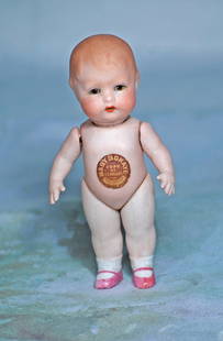 GERMAN ALL-BISQUE, BABY BO KAYE, BY GEORGENE AVERILL: GERMAN ALL-BISQUE, BABY BO KAYE, BY GEORGENE AVERILL. 5”. Marks: Original chest label. Bisque swivel head, sculpted curly brown hair, stationary brown glass eyes, painted lashes, tinted