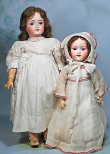 TWO GERMAN BISQUE DOLLS.: 21.TWO GERMAN BISQUE DOLLS. 18” doll by Marseille, marked A.M. 390, socket head, sleep eyes, open mouth, human hair wig, composition ball-jointed body, white organdy dress and bonnet, cloth