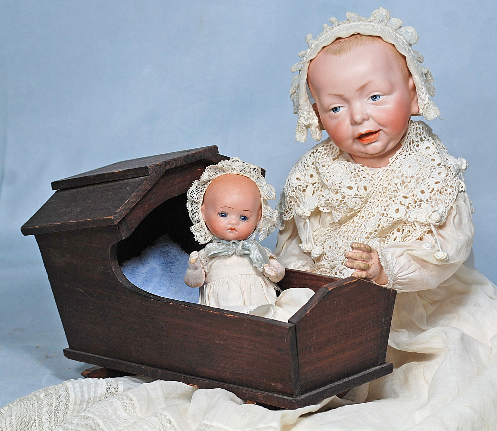 TWO GERMAN BISQUE CHARACTER BABIES AND WOODEN CRADLE. (1 of 1)