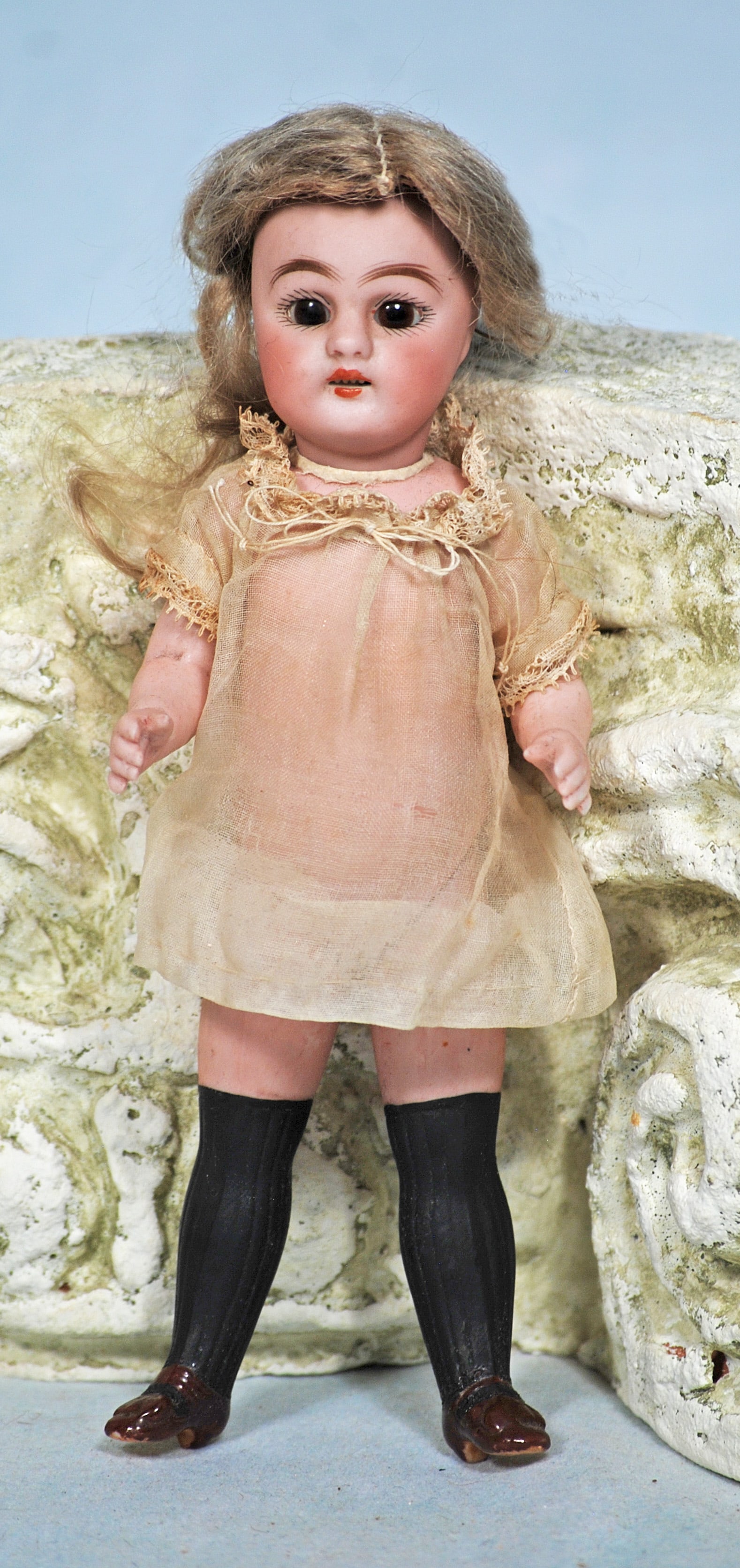 SIMON AND HALBIG ALL-BISQUE BLACK STOCKING GIRL.: 122. SIMON AND HALBIG ALL-BISQUE BLACK STOCKING GIRL. 7”. Marks: 886. Bisque socket head, brown sleep eyes, painted lashes, feathered brows, open mouth, upper teeth, mohair wig, five-piece joint