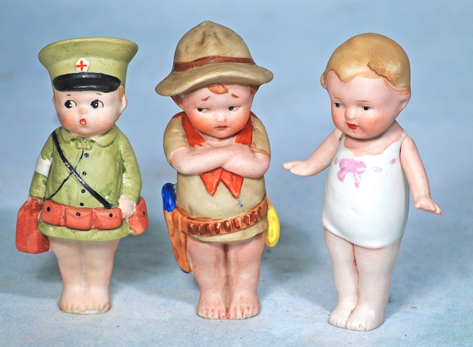 THREE GERMAN ALL-BISQUE DOLLS.: 130.THREE GERMAN ALL-BISQUE DOLLS. 4”. Each is all-bisque with painted hair and features, one has jointed shoulders, two have molded uniform and hat. Commentary: All in very good condition. Esti