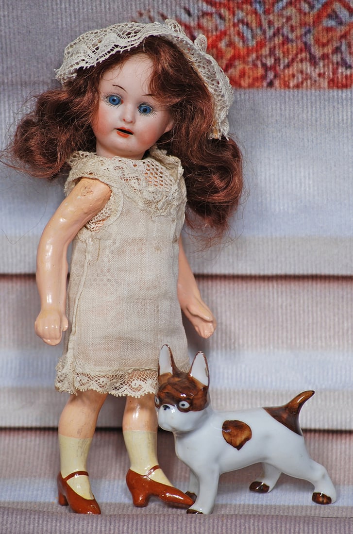 TINY GERMAN BISQUE DOLL WITH PORCELAIN PUP.: TINY GERMAN BISQUE DOLL WITH PORCELAIN PUP. 6". Marks: Germany 14/0. Bisque socket head, blue sleep eyes, painted lashes, tapered brows, open mouth, upper teeth, original brown human hair wig, five-pi