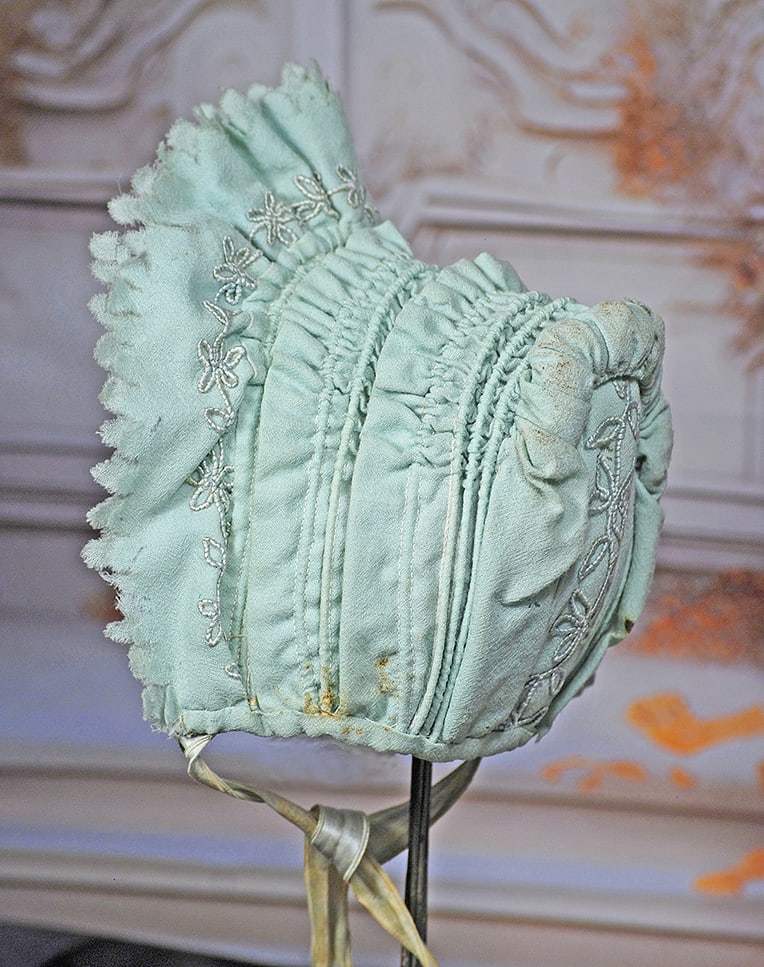 PALE AQUA BLUE WOOL DOLL BONNET.: PALE AQUA BLUE WOOL DOLL BONNET. Wire-framed wool bonnet and ruffled brim with decorative embroidery detail and pinked edges, multiple layers of gathered cording and ruffled, embroidered panel at back