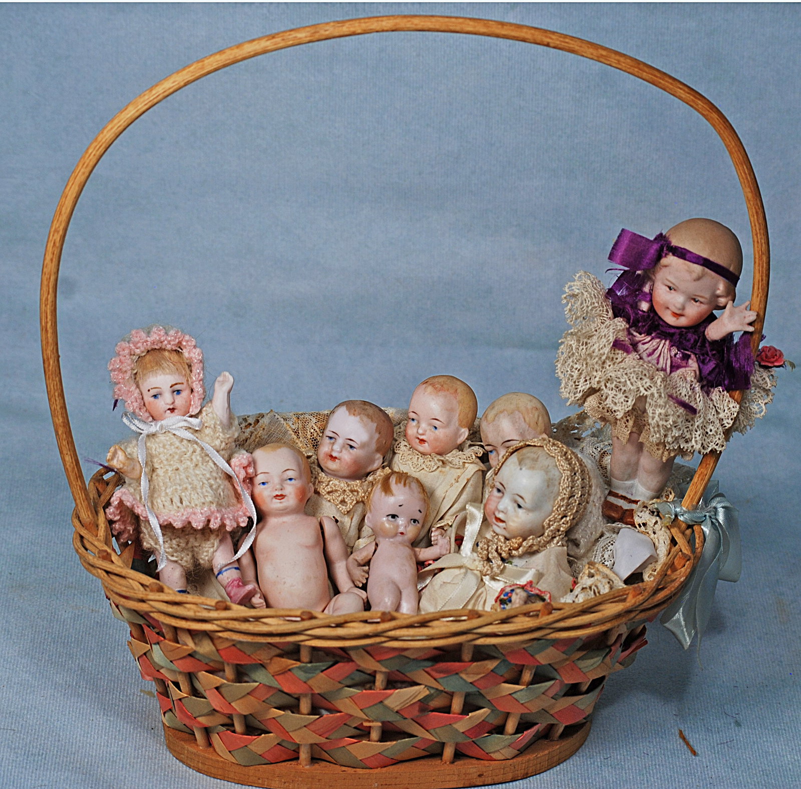 EIGHT GERMAN ALL-BISQUE DOLLS IN BASKET. (1 of 1)