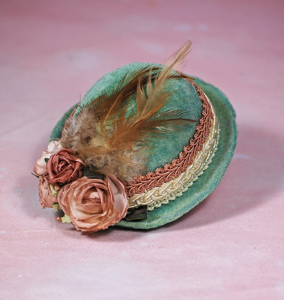 GREEN VELVET DOLL BONNET. Soft green velvet bonnet has firmly shaped high crown with rolled brim,: GREEN VELVET DOLL BONNET. Soft green velvet bonnet has firmly shaped high crown with rolled brim, accented with bands of rose and cream braid, four roses and delicate feathers accenting the brim, for 