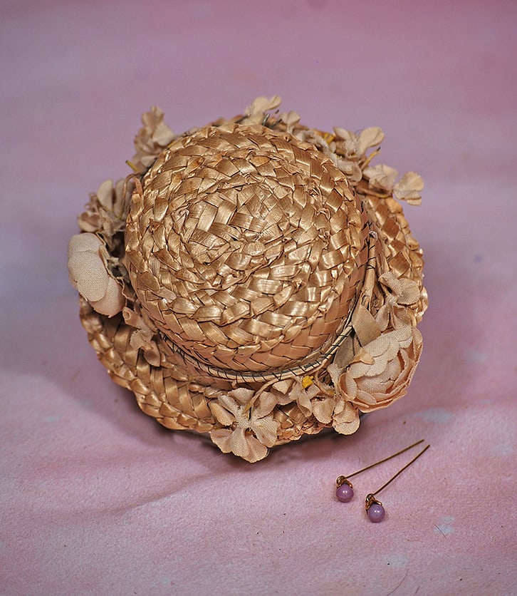 DOLL BONNET. Firmly-shaped straw bonnet with flattened crown, narrow brim encircled by band of (1 of 1)