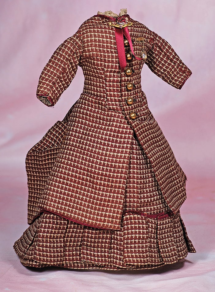 WOOL GOWN FOR FASHION DOLL. Maroon and cream patterned wool two-piece gown comprising fitted long: WOOL GOWN FOR FASHION DOLL. Maroon and cream patterned wool two-piece gown comprising fitted long jacket with inset sleeves, front closing with gold buttons, decorative pin and maroon silk bow at neck