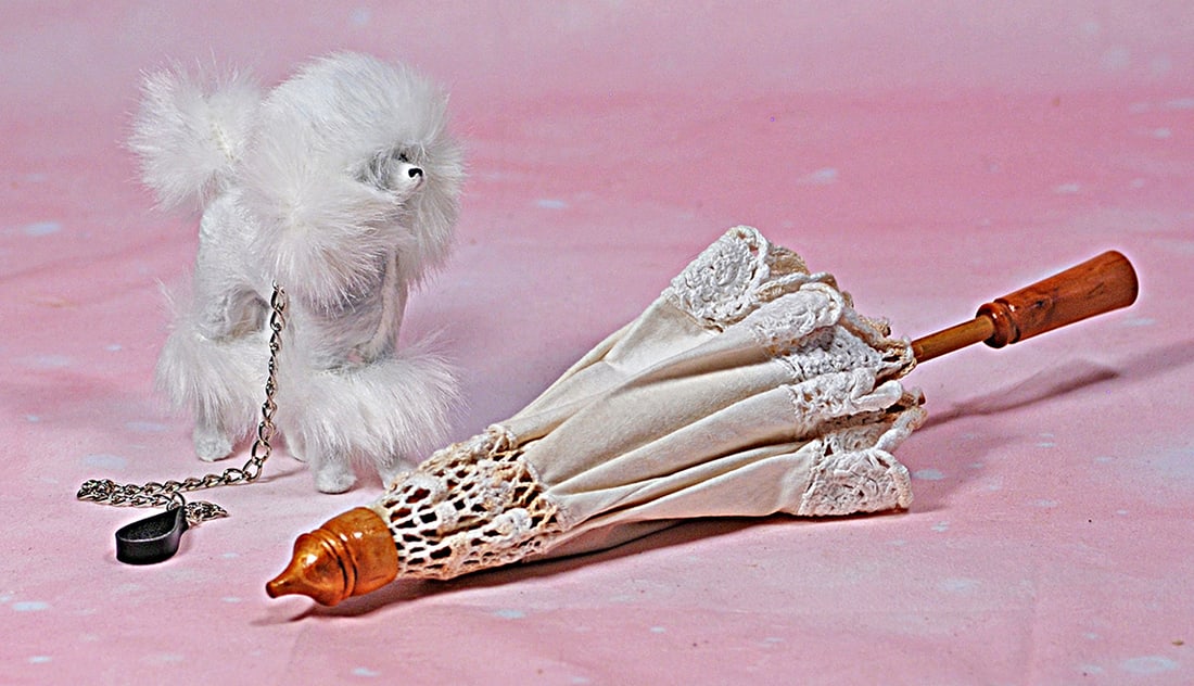 WHITE FURRY DOG AND LACE PARASOL. 5” white plush fur French poodle with leash; 12”white: WHITE FURRY DOG AND LACE PARASOL. 5” white plush fur French poodle with leash; 12”white cotton parasol. Commentary: Contemporary maker, good condition.