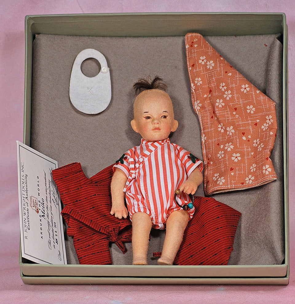 R. JOHN WRIGHT “MEIKO”. 6 ½”. Fully-jointed all felt with hand painted: R. JOHN WRIGHT “MEIKO”. 6 ½”. Fully-jointed all felt with hand painted features and inset mohair wig, kimono-style cotton onsie with embroidered cherries, holds wooden and leath