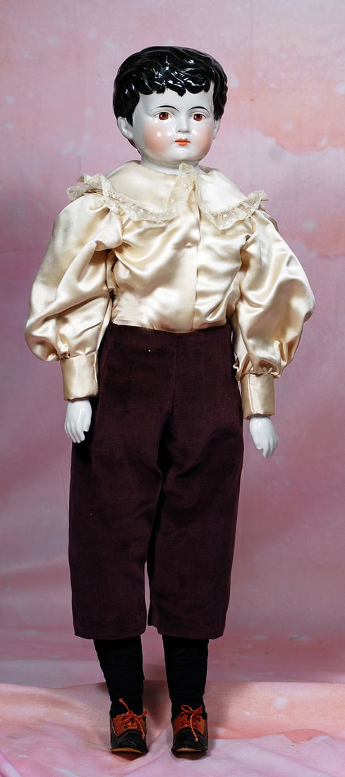 GERMAN BISQUE PORCELAIN GENTLEMAN WITH BROWN EYES. 24”. Porcelain shoulderhead, painted black: GERMAN BISQUE PORCELAIN GENTLEMAN WITH BROWN EYES. 24”. Porcelain shoulderhead, painted black hair in boyish style with brush-marked detail framing the face, fully-modeled ears, deeply-sculpted