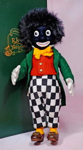 R.JOHN WRIGHT “BON VOAGE” DOLL.: 102 R. JOHN WRIGHT GOLLIWOG. 11”. All-felt doll with swivel head, jointed body, large round googly eyes, mohair wig, dressed in colorful felt costume, hand-cobbled brown leather shoes. RJW tag a