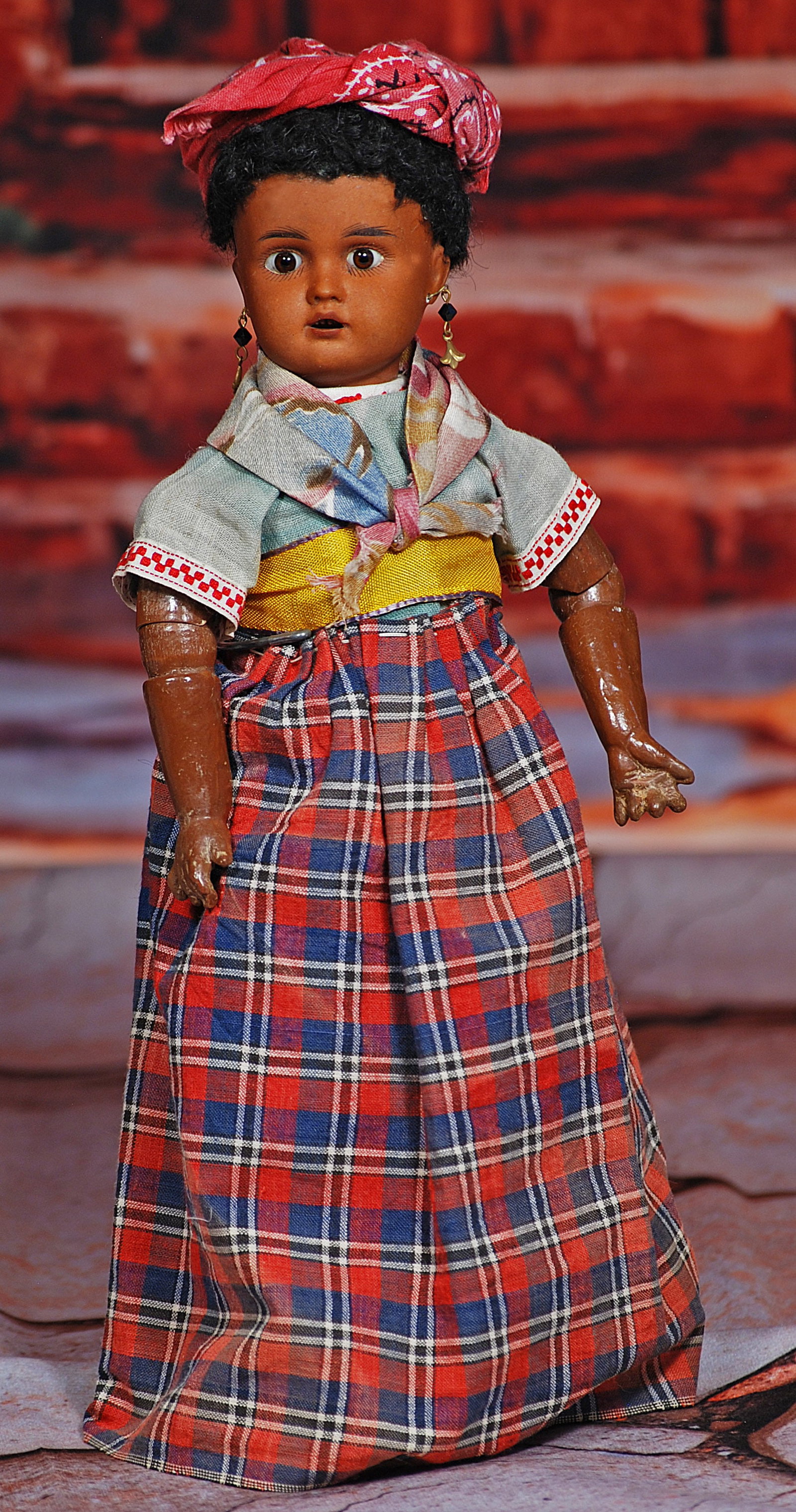 GERMAN BISQUE BROWN-COMPLEXIONED DOLL IN PROVINCIAL COSTUME.: 136. GERMAN BISQUE BROWN-COMPLEXIONED DOLL IN PROVINCIAL COSTUME. 11 ½”. Marks: Dep. Brown bisque socket head, stationary brown glass eyes, painted lashes, feathered brows, open mouth, up