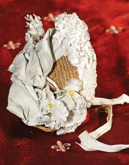 ANTIQUE STRAW BONNET WITH LAVISH DECORATION. 3 ¾”: ANTIQUE STRAW BONNET WITH LAVISH DECORATION. 3 ¾” inside cap width. Woven straw bonnet in natural finish has upturned brim which is decorated with multiple rows of thickly-pleated lace and silk rib