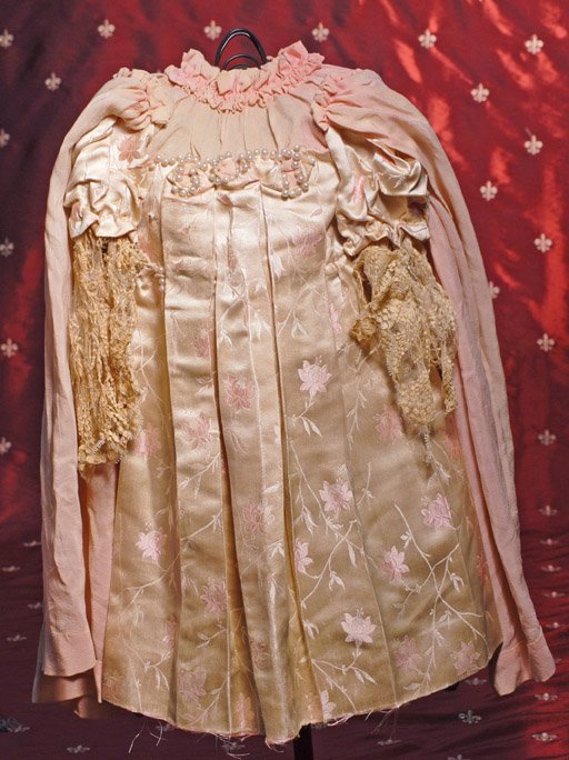 ANTIQUE FRENCH SILK DRESS FOR JUMEAU BEBE. 6 ½” s: ANTIQUE FRENCH SILK DRESS FOR JUMEAU BEBE. 6 ½” shoulder width, 21” length. Pink embroidered silk-satin fabric dress with inset shirred yoke of pink silk crepe, puffed sleeves with lace below, ga