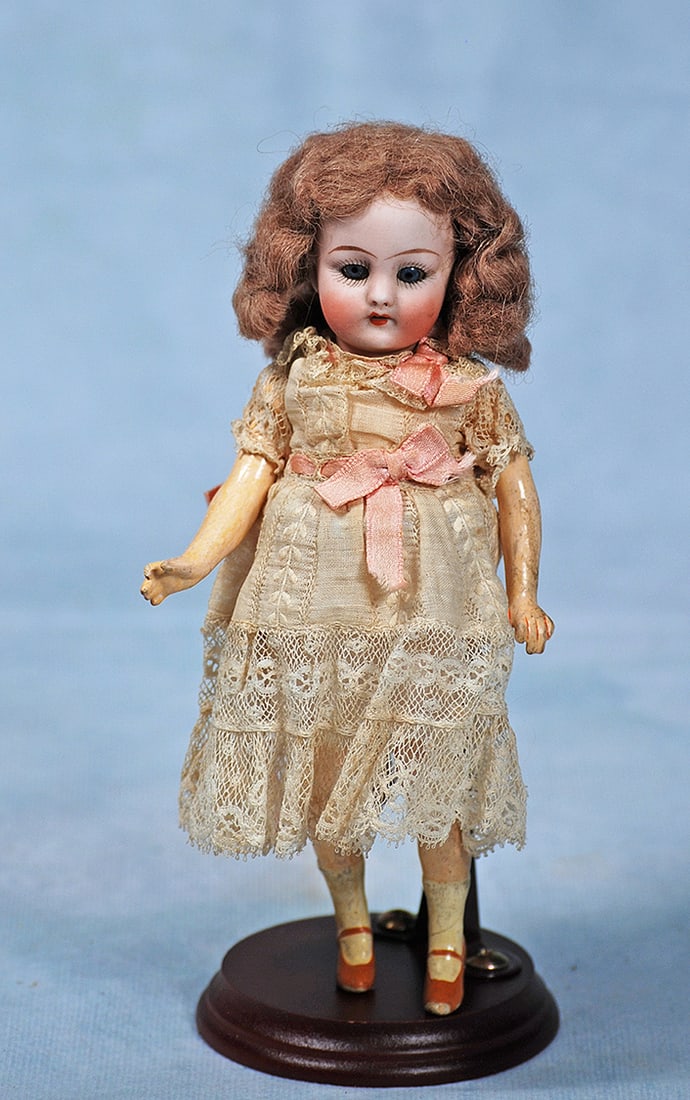 PETITE SIMON AND HALBIG BISQUE DOLL IN ORIGINAL DRESS: PETITE SIMON AND HALBIG BISQUE DOLL IN ORIGINAL DRESS. 7”. Marks: 1078 Simon & Halbig. Bisque socket head, blue sleep eyes, painted lashes, tapered brows, open mouth, upper teeth, original brown