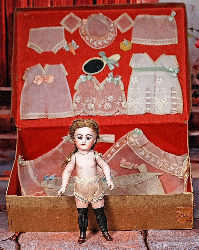 LARGE SIMON AND HALBIG BLACK-STOCKING GIRL IN PRESENTATION BOX: LARGE SIMON AND HALBIG BLACK-STOCKING GIRL IN PRESENTATION BOX. 9”. Marks: 689 S 9 H. Bisque swivel head, five-piece jointed bisque body, painted over-the-knee black stockings and brown one-stra