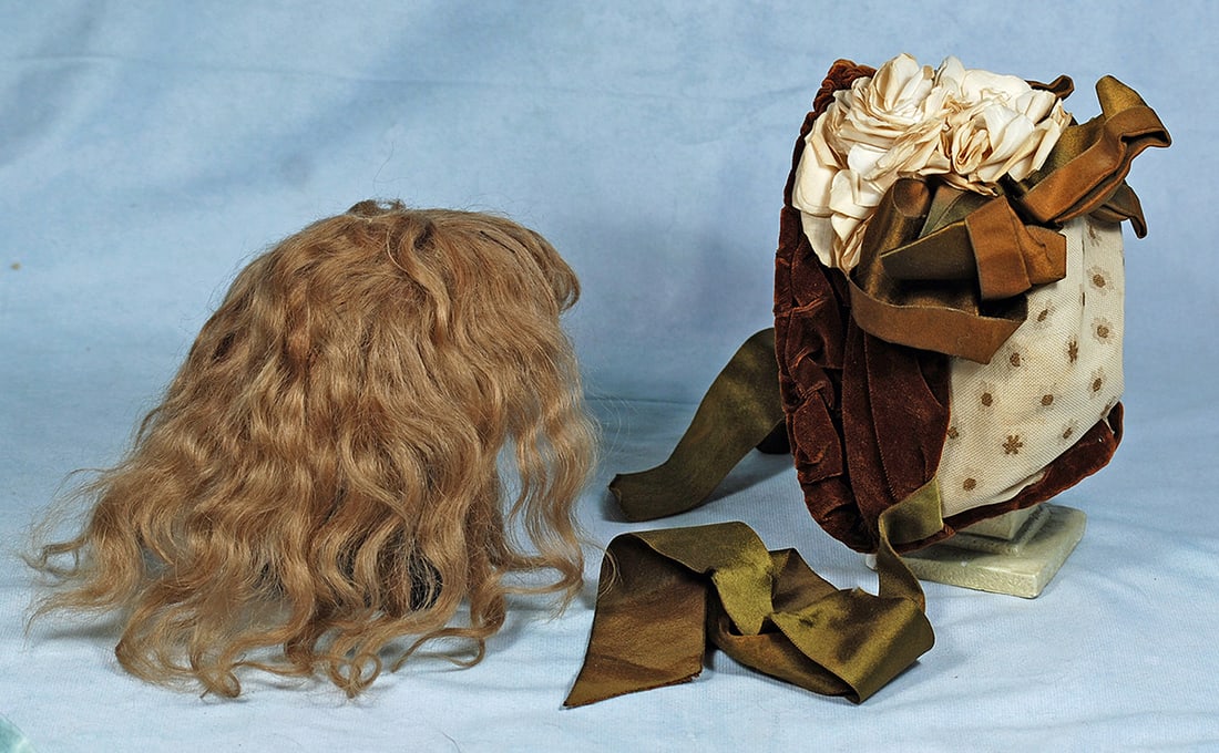 VELVET AND COTTON DOLL BONNET: VELVET AND COTTON DOLL BONNET. Cream and tan patterned cotton bonnet has brown velvet gathered brim, wire framing, velvet band, accented with wide brown silk bows and topped with cluster of cream flow