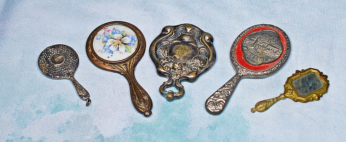 FIVE MINIATURE ANTIQUE MIRRORS: FIVE MINIATURE ANTIQUE MIRRORS. 2 ¾” to 4”. Hand mirrors with embossed metal designs and various decorative details. Commentary: Good condition with age wear.
