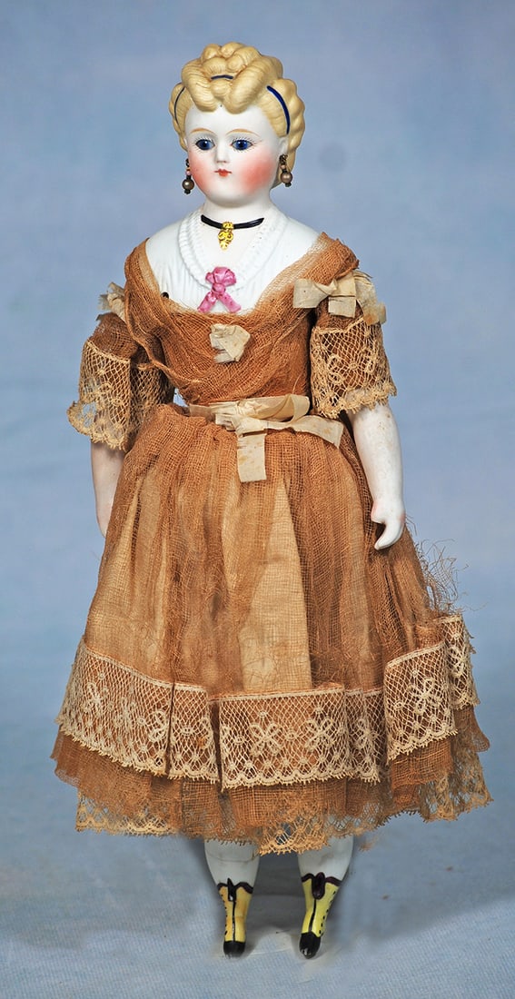 GERMAN BISQUE LADY WITH GLASS EYES AND SCULPTED HAIR: GERMAN BISQUE LADY WITH GLASS EYES AND SCULPTED HAIR. 11 ½”. Bisque shoulderhead with sculpted blonde hair arranged in detailed rolled curls accented with blue ribbons at front and back, pi