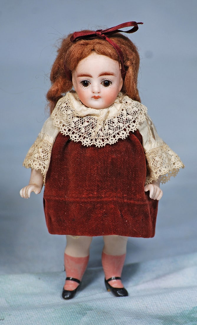 GERMAN ALL-BISQUE DOLL WITH PINK STOCKINGS: GERMAN ALL-BISQUE DOLL WITH PINK STOCKINGS. 6”. Marks: None. All-bisque, jointed at shoulders and hips, stationary brown glass eyes, painted lashes, tapered brows, closed mouth, mohair wig, pain