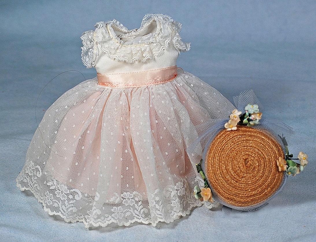 DOLL DRESS AND BONNET: DOLL DRESS AND BONNET. White lace over pink cotton dress has rounded neckline, lace ruffled sleeves, full gathered skirt, pink ribbon sash, 2 ½” shoulder width, 6 ½” length, plus
