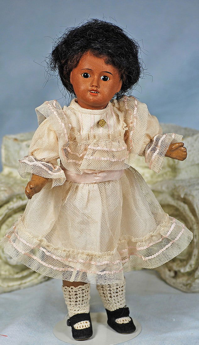 FRENCH BISQUE, BROWN-COMPLEXIONED DOLL UNIS: FRENCH BISQUE, BROWN-COMPLEXIONED DOLL UNIS. 10”. Marks: Unis France 60. Brown bisque socket head, stationary brown glass eyes, tapered brows, open mouth, upper teeth, black curly wig, five-piec