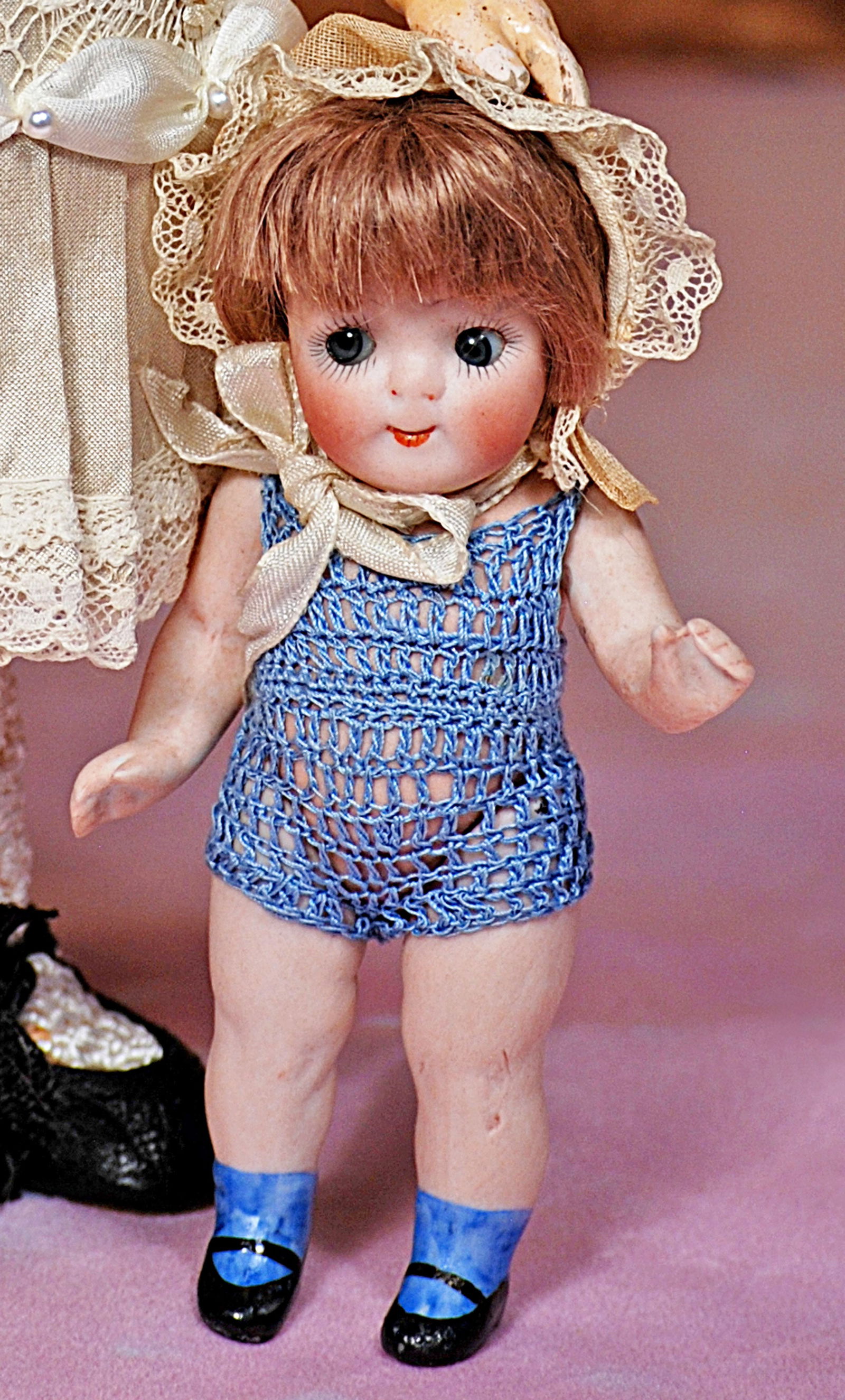 TINY GERMAN ALL-BISQUE GOOGLY, 189, BY KESTNER: TINY GERMAN ALL-BISQUE GOOGLY, 189, BY KESTNER. 4 ½”. Marks: 189, plus Kestner sticker on chest. Bisque swivel head on five-piece jointed bisque body with painted blue socks and black one
