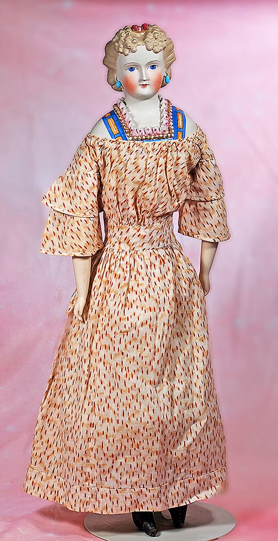 GERMAN BISQUE LADY WITH SCULPTED HAIR AND BODICE: GERMAN BISQUE LADY WITH SCULPTED HAIR AND BODICE. 23”. Marks: None. Bisque shoulderhead with sculpted blonde hair arranged in cluster of tiny curls at the front, sides drawn away from face into