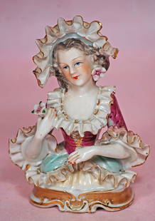 GERMAN PORCELAIN HALF DOLL WITH FANCY SCULPTED BONNET AND BODICE: GERMAN PORCELAIN HALF DOLL WITH FANCY SCULPTED BONNET AND BODICE. 5 &#188;&#8221;. Marks: Green criss-cross mark. Waist-up porcelain figure of elegant lady with sculpted flowing brown hair, sculpted b