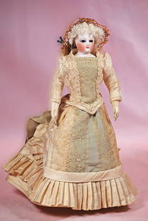 PETITE FRENCH BISQUE POUPEE: PETITE FRENCH BISQUE POUPEE. 11”. Marks: 2/o. Bisque shoulderhead, inset cobalt blue glass eyes, painted lashes, multi-stroked brows, closed mouth, unpierced ears, lamb skin wig over cork