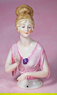GERMAN PORCELAIN HALF DOLL WITH RARE COIFFURE: GERMAN PORCELAIN HALF DOLL WITH RARE COIFFURE. 5 &#189;&#8221;. Marks: 4626. Waist-up porcelain figure of lady with sculpted light brown hair in elaborate coiffure with braided detail, painted downwar