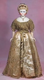 GERMAN BISQUE LADY WITH GLASS EYES, SCULPTED HAIR AND JEWELLED ORNAMENT