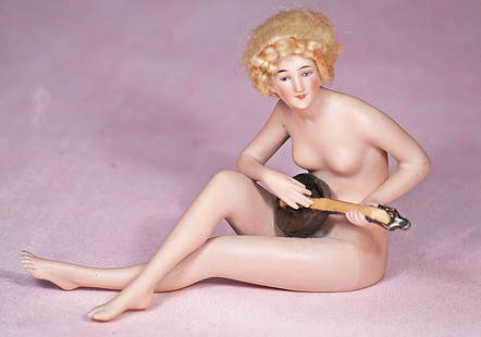 GERMAN ALL-BISQUE NUDE LADY WITH MANDOLIN: GERMAN ALL-BISQUE NUDE LADY WITH MANDOLIN. 5&#8221; x 3 &#189;&#8221;. Marks: None. All-bisque nude lady in seated posed with legs crossed and holding a sculpted bisque mandolin, slender face with pai