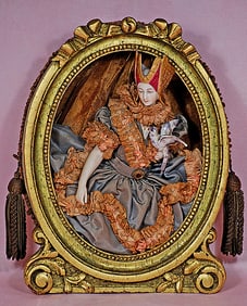 FRAMED GERMAN PORCELAIN HALF DOLL WITH JOINTED ARMS, RARE HEADDRESS AND HOLDING A BIRD